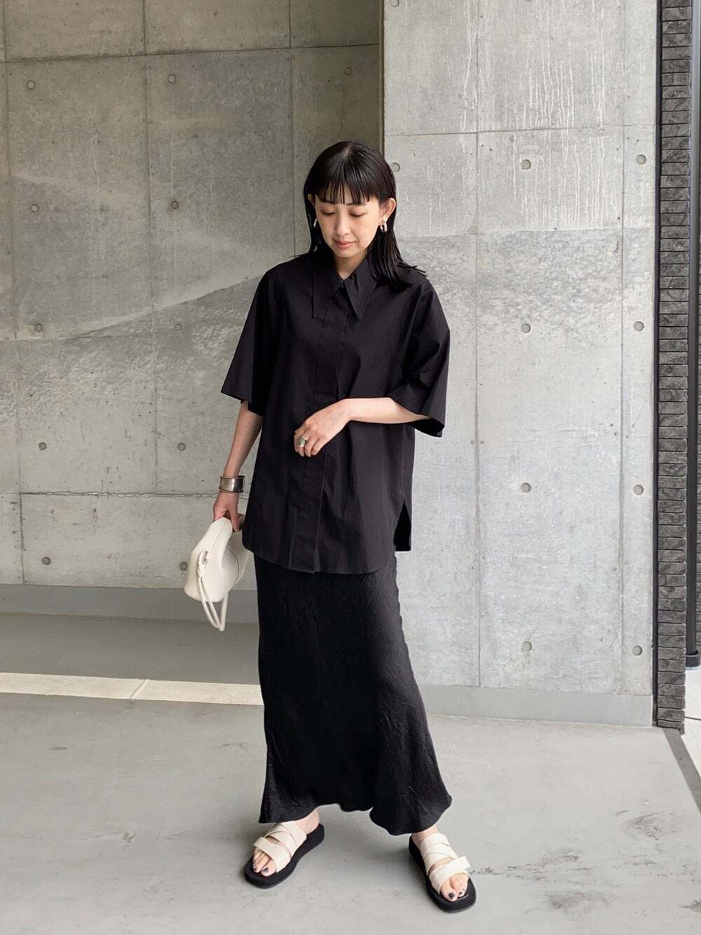 ブラック系のシャツ/ブラウス、ブラック系のスカート、ホワイト系のショルダーバッグを着用したレディースの夏コーディネートの3枚目の写真
