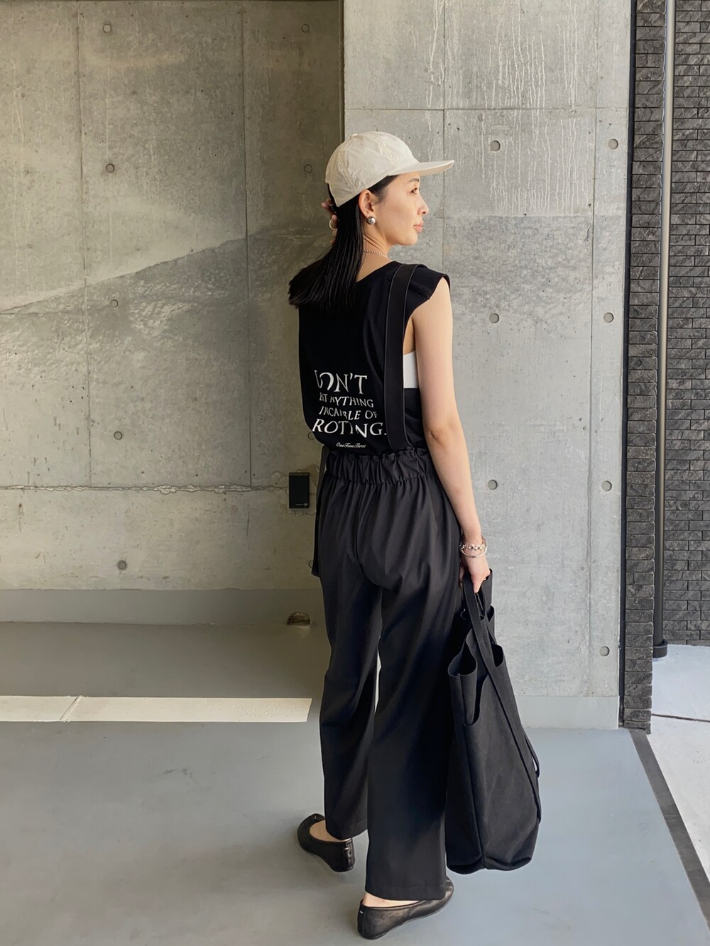 ブラック系のトートバッグ、ブラック系のバレエシューズ、ブラック系のTシャツ/カットソーを着用したレディースの夏コーディネートの4枚目の写真