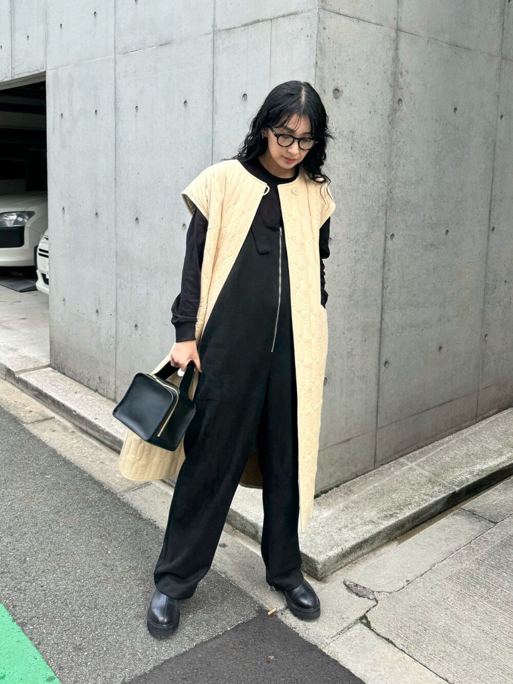 ブラック系のサロペット/オーバーオール、ブラック系のブーツ、ベージュ系のミリタリージャケットを着用したレディースの冬コーディネートの4枚目の写真