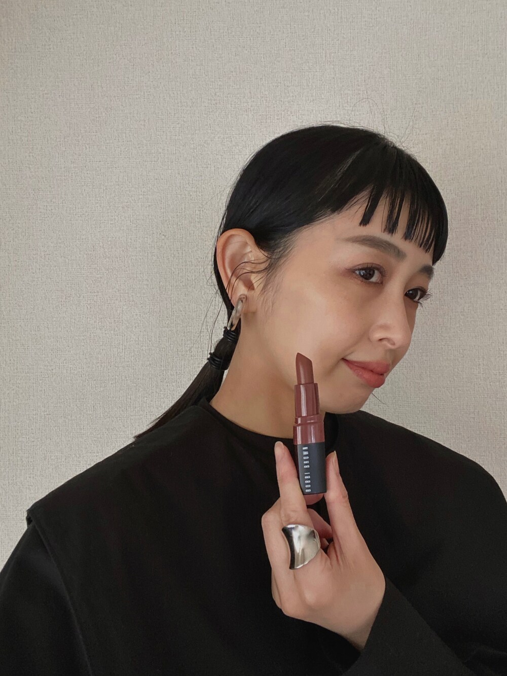 ブラック系のシャツ/ブラウス、ブルー系のハンドバッグ、ホワイト系のチェスターコートを着用したレディースの冬コーディネートの5枚目の写真