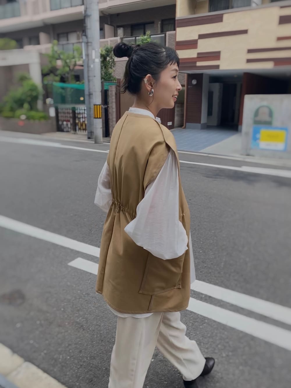 ホワイト系のシャツ/ブラウス、ブラック系のブーツ、ベージュ系のベストを着用したレディースの秋コーディネートの4枚目の写真