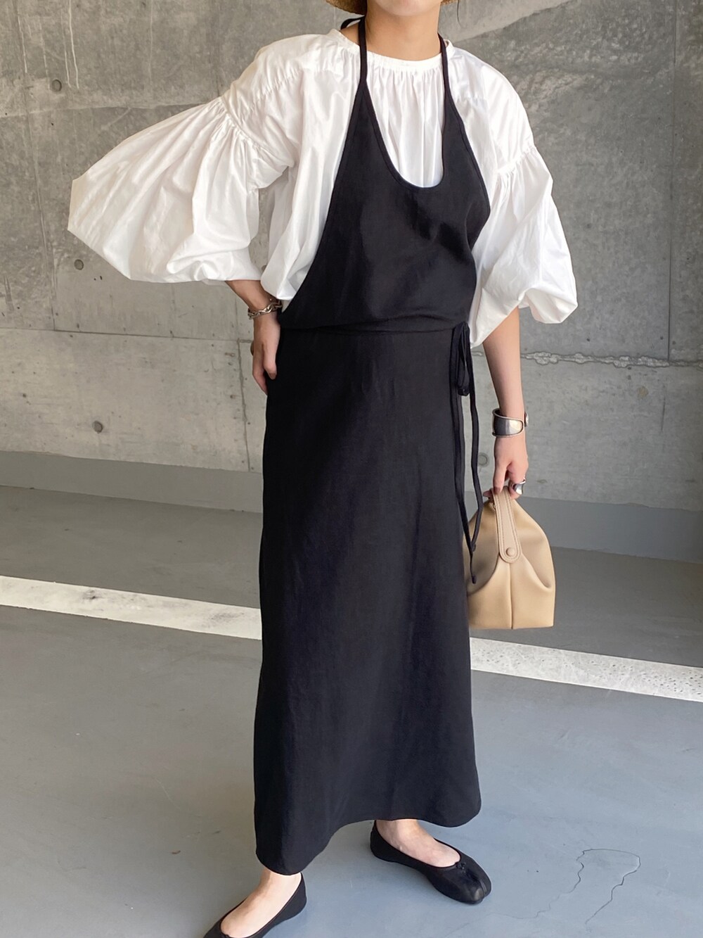 ブラック系のワンピース、ホワイト系のシャツ/ブラウス、ベージュ系のハンドバッグを着用したレディースの秋コーディネートの3枚目の写真