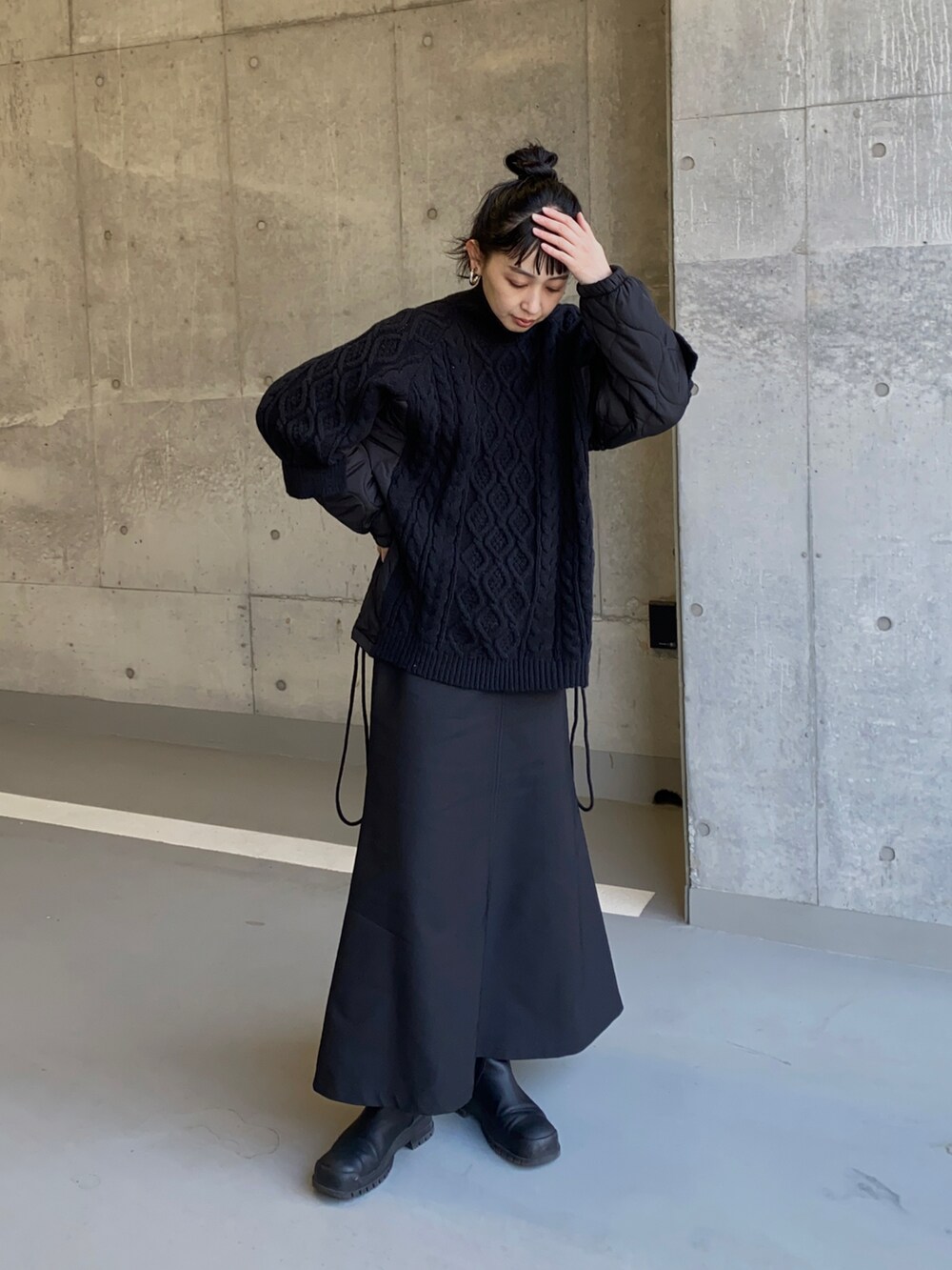 ブラック系のニット/セーター、ブラック系のスカートを着用したレディースの冬コーディネートの2枚目の写真