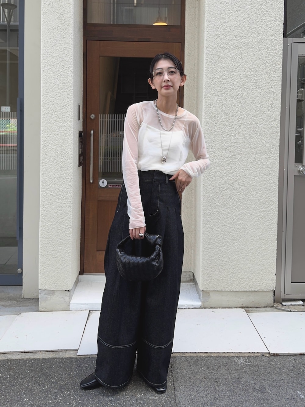 ブラック系のデニムパンツ、ホワイト系のキャミソール、ホワイト系のTシャツ/カットソーを着用したレディースの秋コーディネートの4枚目の写真