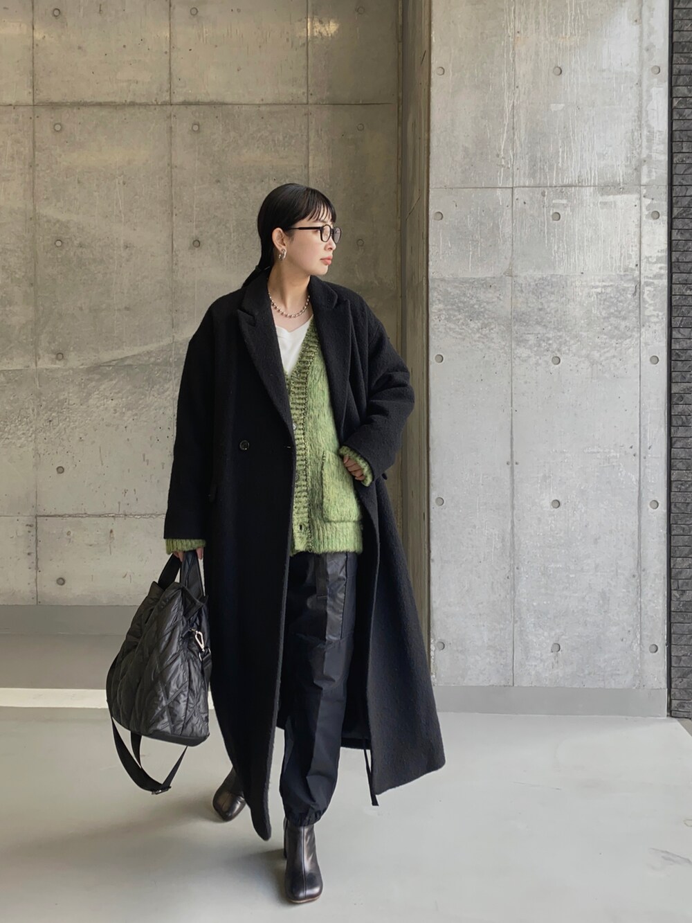 ブラック系のチェスターコート、ブラック系のトートバッグを着用したレディースの冬コーディネートの3枚目の写真