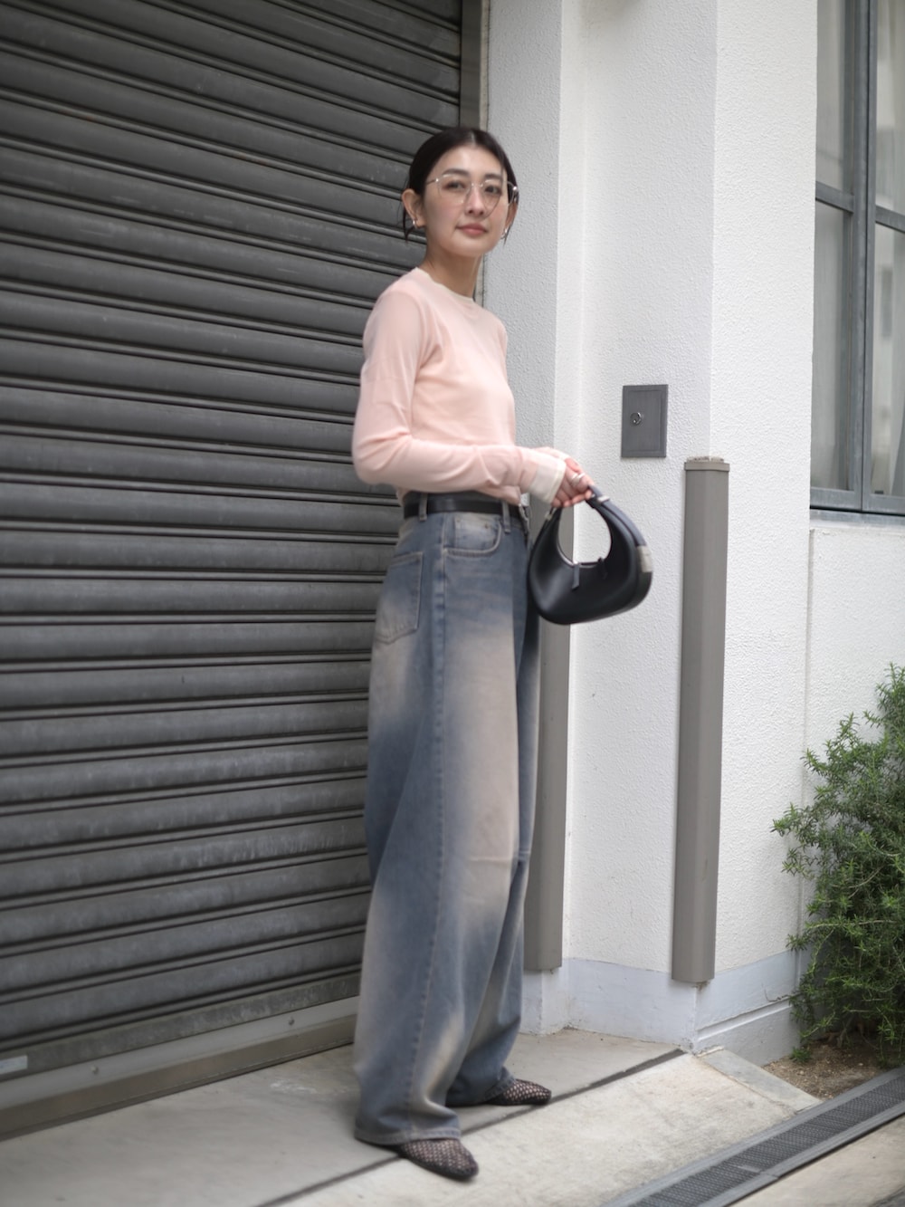 ピンク系のTシャツ/カットソー、ブラック系のハンドバッグ、ブルー系のデニムパンツを着用したレディースの春コーディネートの3枚目の写真