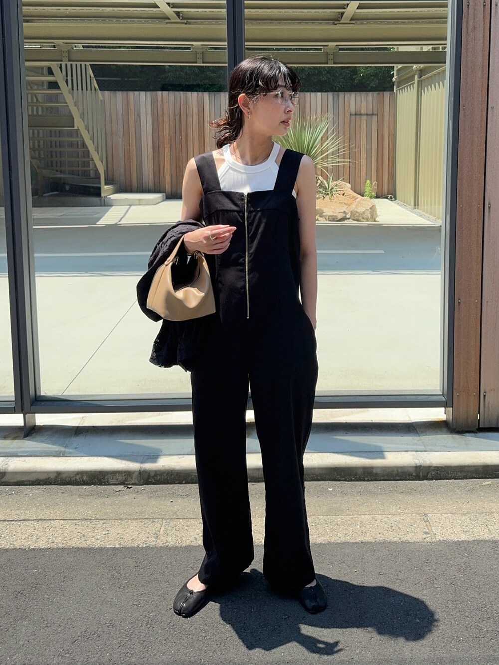 ブラック系のサロペット/オーバーオール、ホワイト系のタンクトップ、ブラック系のバレエシューズを着用したレディースの夏コーディネートの4枚目の写真