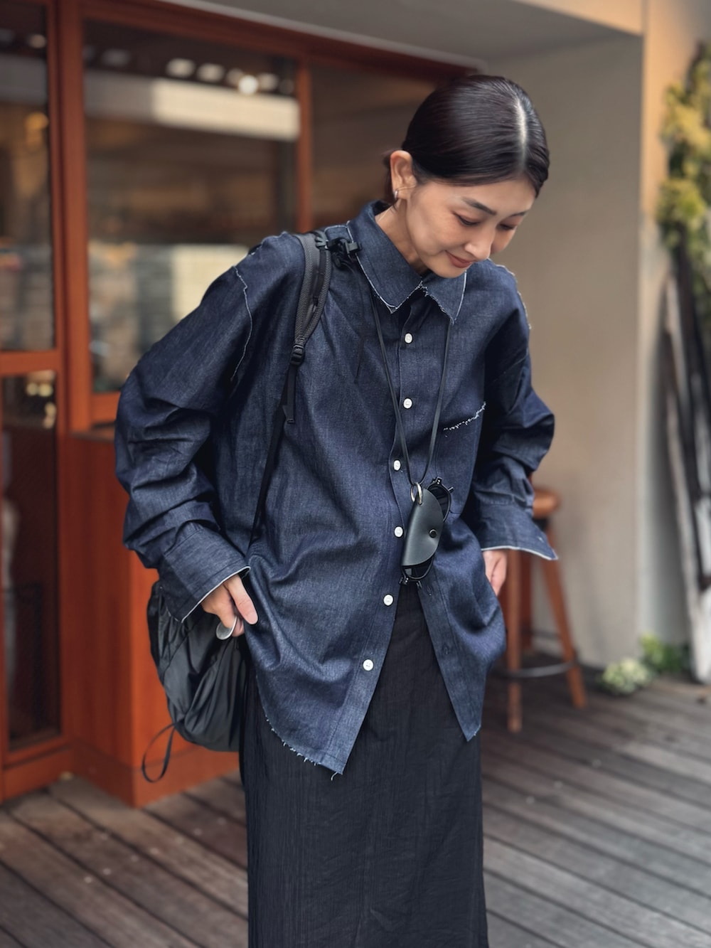 ブルー系のシャツ/ブラウス、ブラック系のスラックス、ブラック系のバックパック/リュックを着用したレディースの夏コーディネートの3枚目の写真