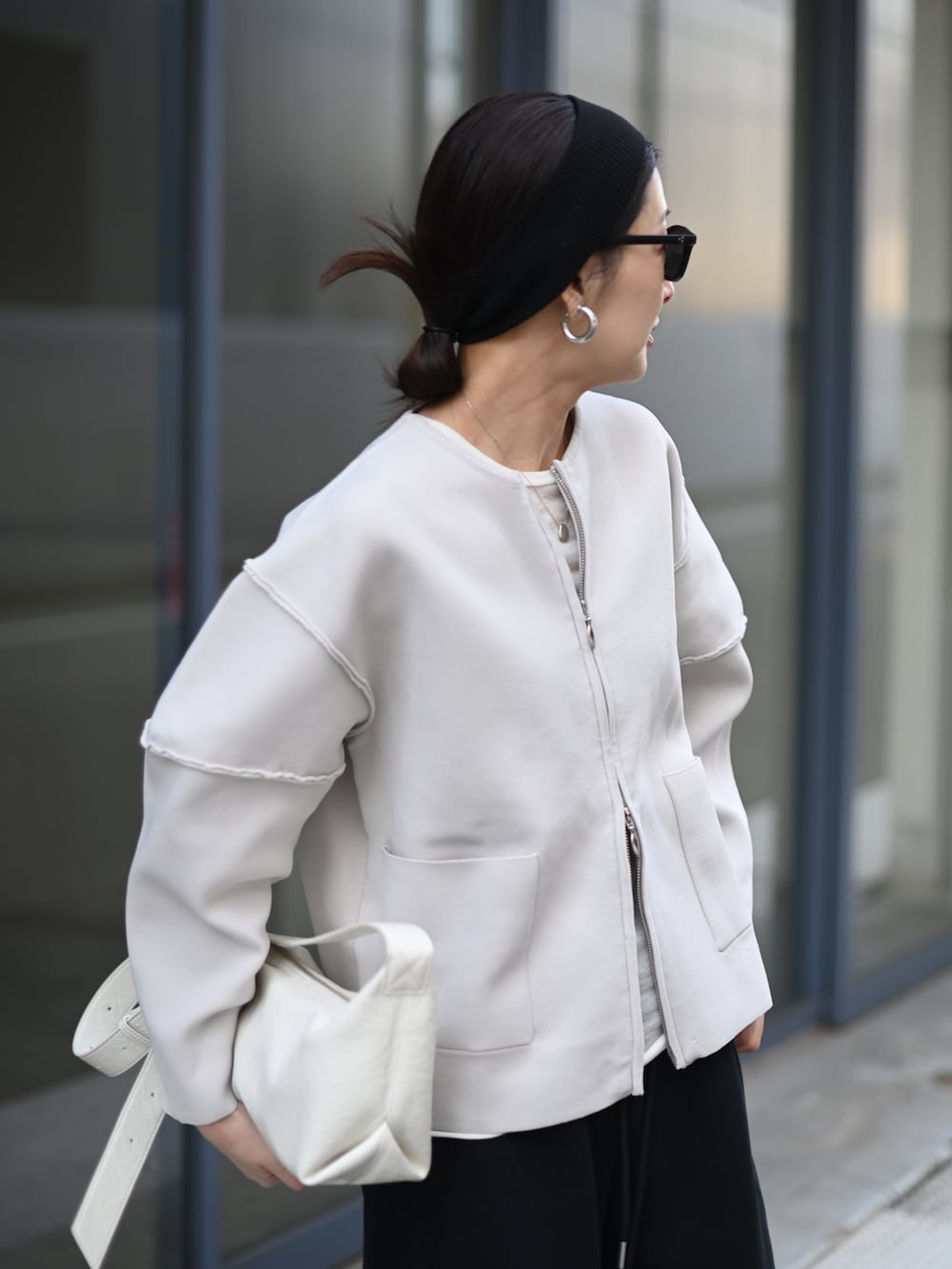 グレー系のカーディガン/ボレロ、ブラック系のスウェットパンツ、ホワイト系のスニーカーを着用したレディースの冬コーディネートの3枚目の写真