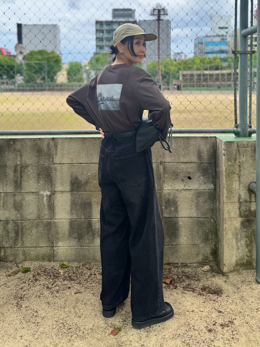 ブラック系のデニムパンツ、グレー系のTシャツ/カットソー、ブラック系のローファーを着用したレディースの春コーディネートの4枚目の写真