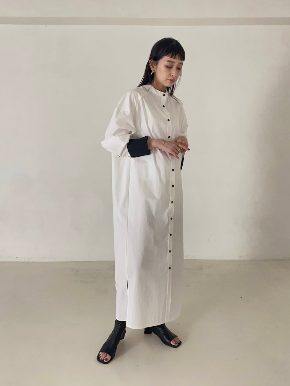 ホワイト系のシャツワンピース、ブラック系のブーツを着用したレディースの秋コーディネートの4枚目の写真