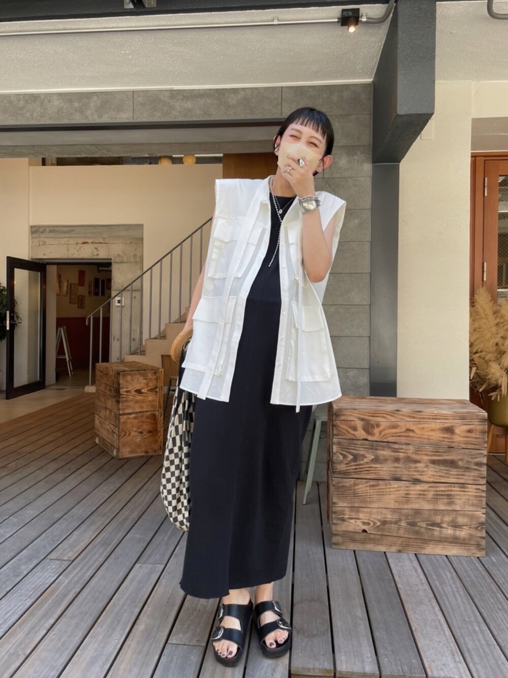 ブラック系のワンピース、ブラック系のサンダル、ブラック系のトートバッグを着用したレディースの夏コーディネートの3枚目の写真