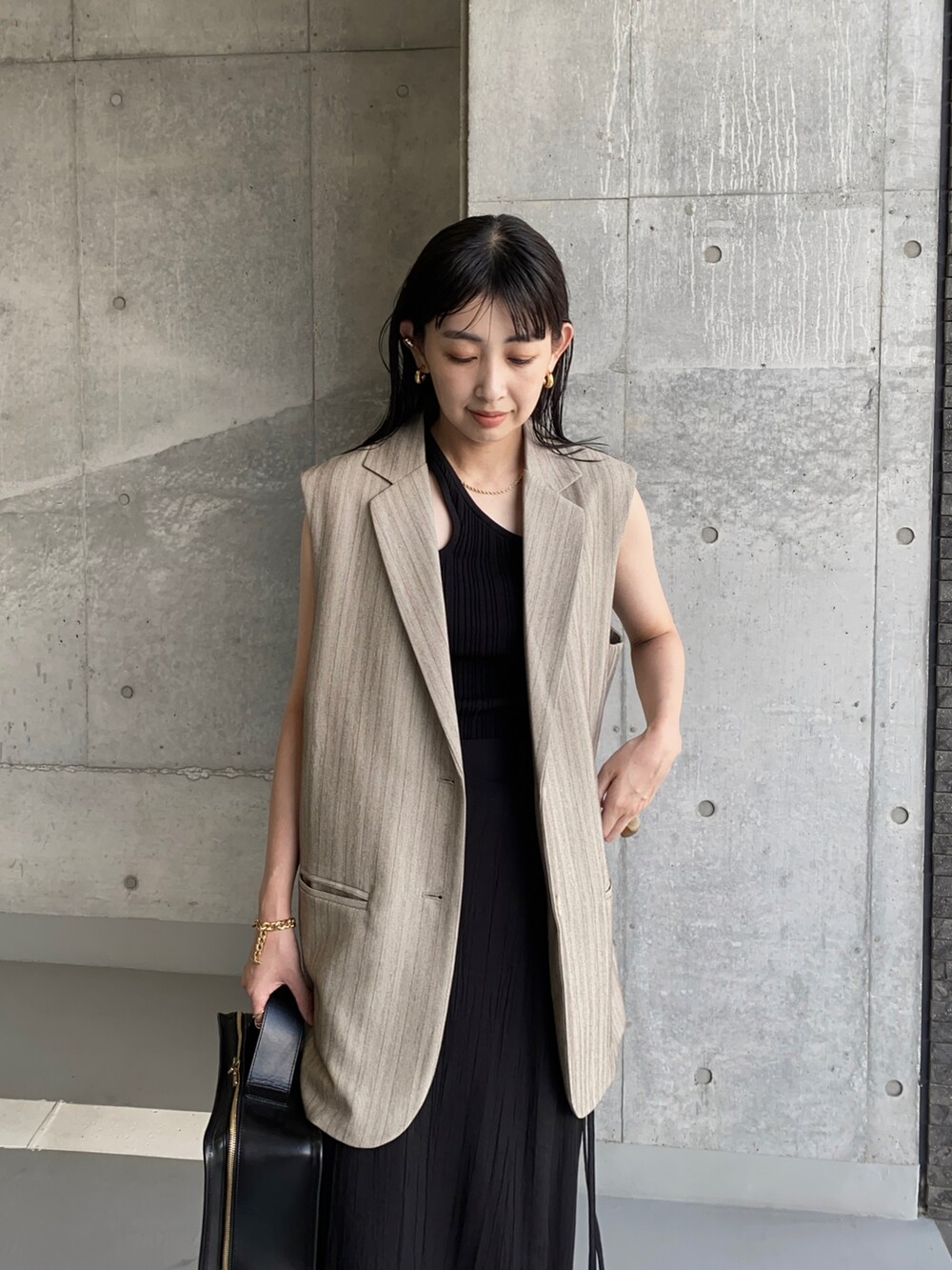 ベージュ系のその他アウター、ブラック系のその他パンツ、ブラック系のハンドバッグを着用したレディースの秋コーディネートの2枚目の写真