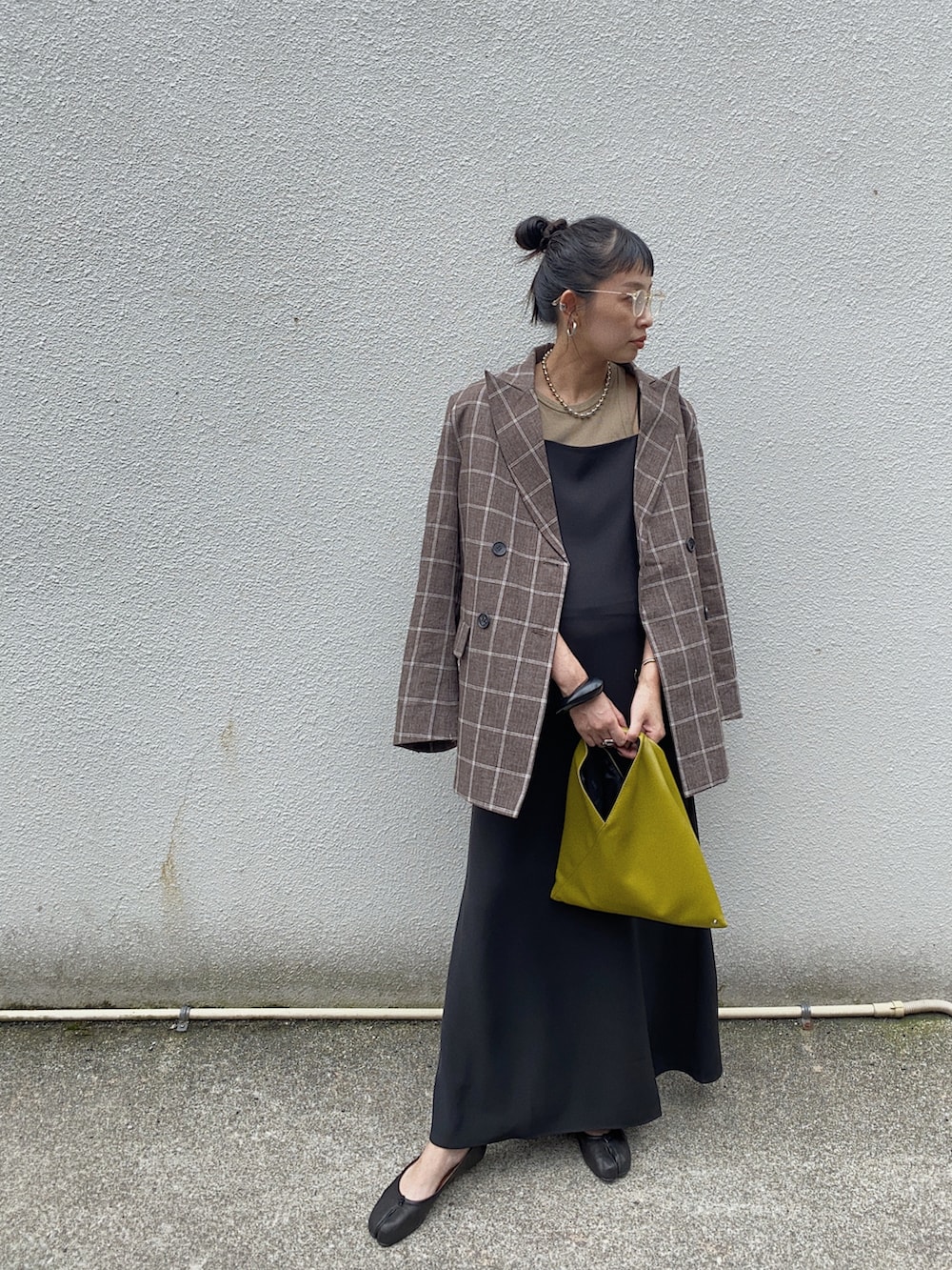 ブラウン系のテーラードジャケット、ブラック系のワンピース、イエロー系のハンドバッグを着用したレディースの秋コーディネートの2枚目の写真