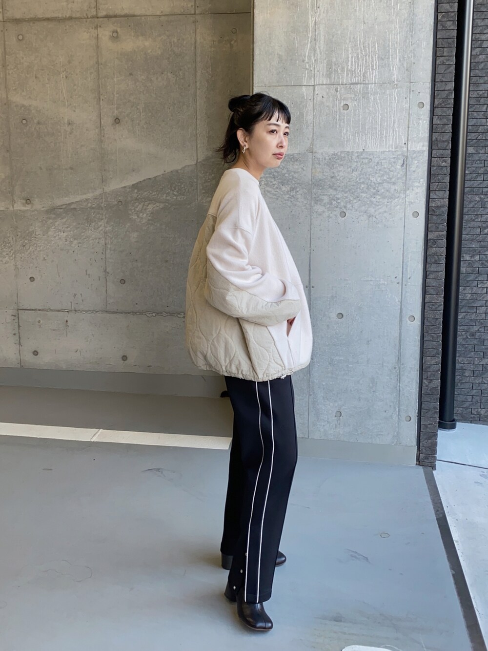 ホワイト系のその他トップス、ブラック系のその他パンツ、ブラック系のブーツを着用したレディースの冬コーディネートの3枚目の写真