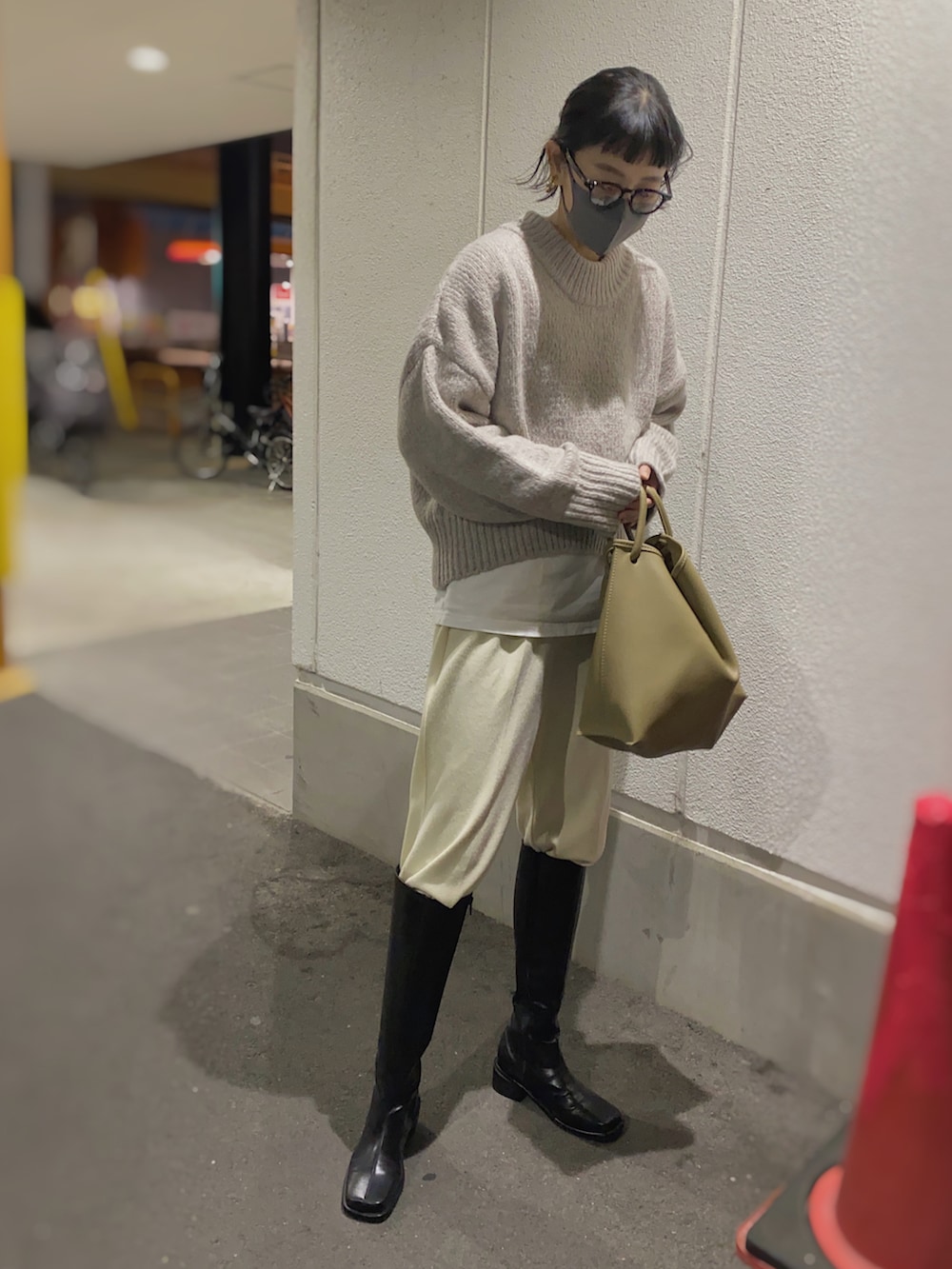ベージュ系のニット/セーター、ベージュ系のバッグ、ブラック系のメガネを着用したレディースの冬コーディネートの2枚目の写真