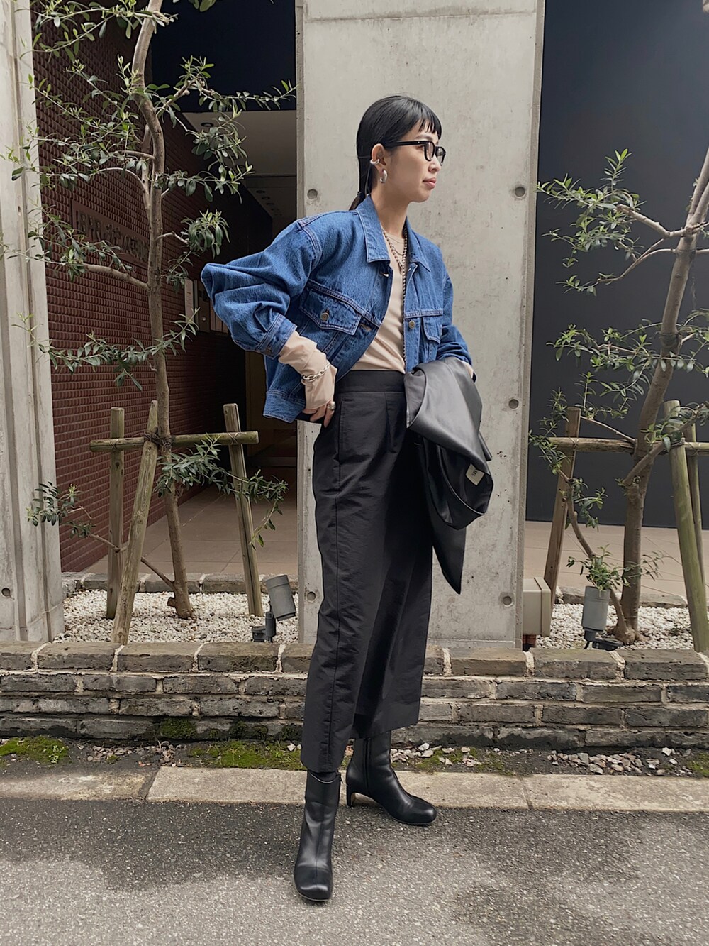 ブルー系のデニムジャケット、ブラック系のベスト、ベージュ系のTシャツ/カットソーを着用したレディースの冬コーディネートの3枚目の写真