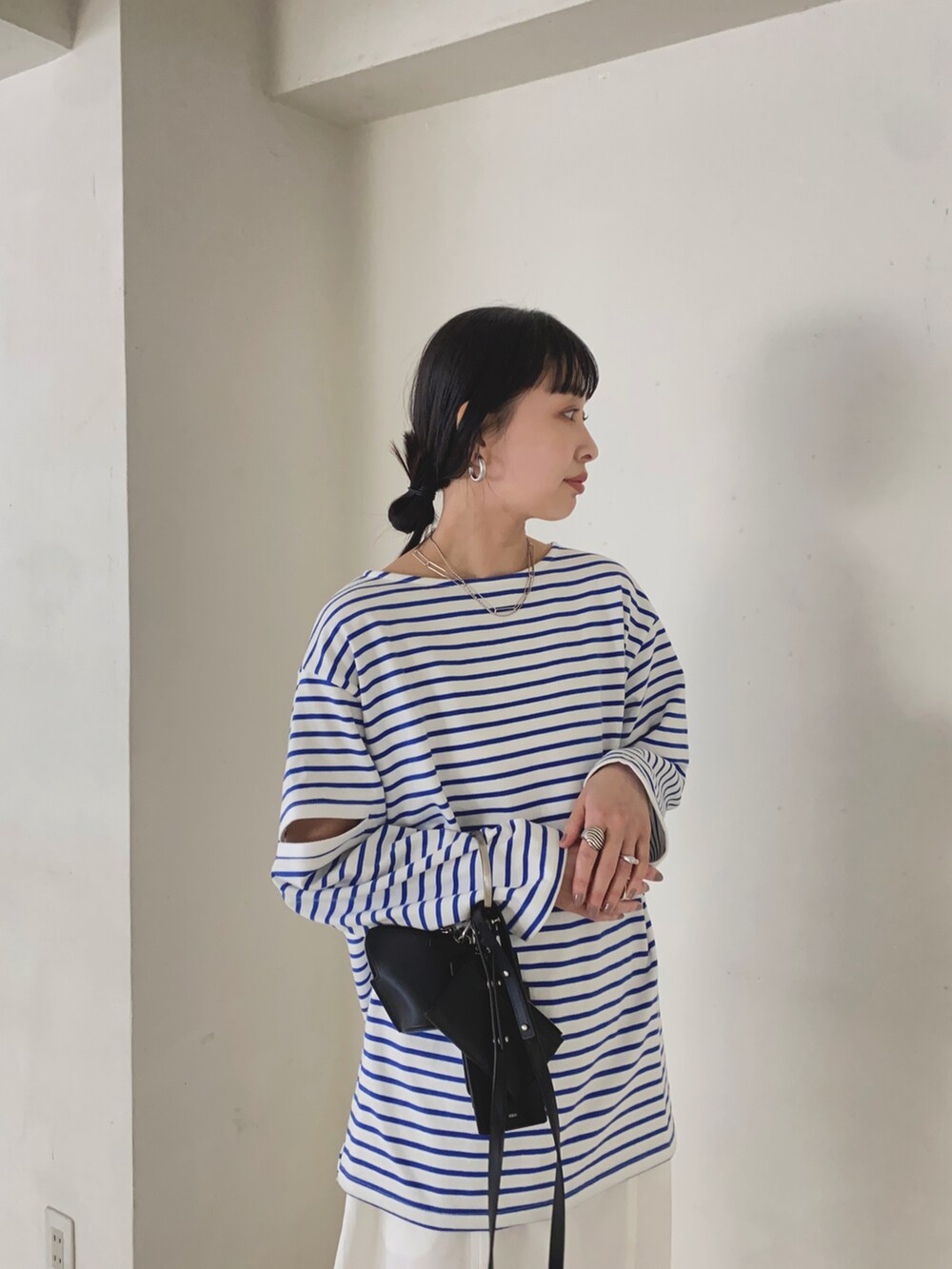 ブルー系のTシャツ/カットソー、ホワイト系のチノパンツ、ブラック系のショルダーバッグを着用したレディースの春コーディネートの2枚目の写真