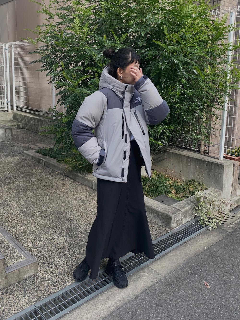 グレー系のその他アウター、ブラック系のスカート、ブラック系のスニーカーを着用したレディースの冬コーディネートの3枚目の写真