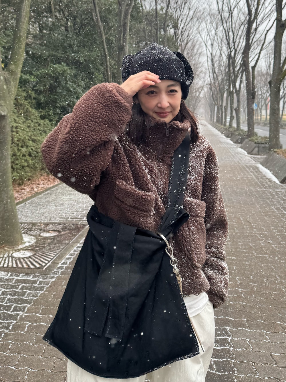 ブラウン系のその他アウター、ブラック系のトートバッグ、ホワイト系のその他パンツを着用したレディースの冬コーディネートの3枚目の写真