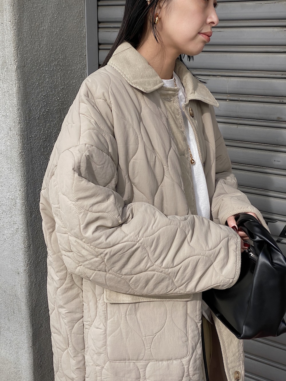 ベージュ系のダウンジャケット/コート、ブラック系のブーツを着用したレディースの冬コーディネートの3枚目の写真