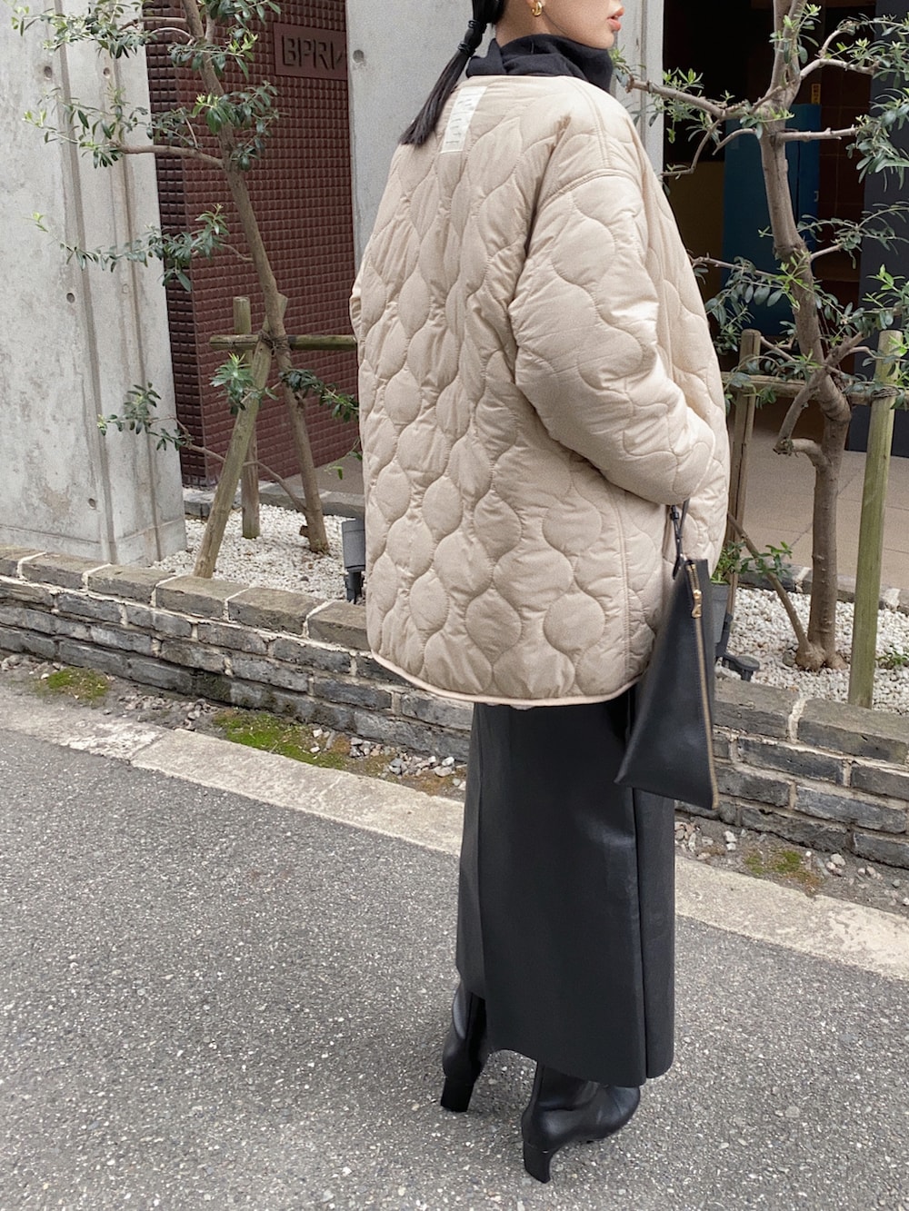 ベージュ系のブルゾン、ブラック系のニット/セーター、ブラック系のショルダーバッグを着用したレディースの秋コーディネートの3枚目の写真