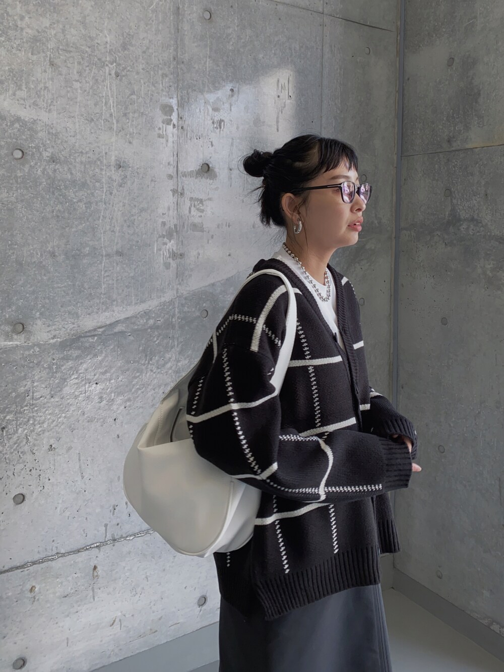 ブラック系のカーディガン/ボレロ、ブラック系のスカート、ホワイト系のトートバッグを着用したレディースの冬コーディネートの2枚目の写真