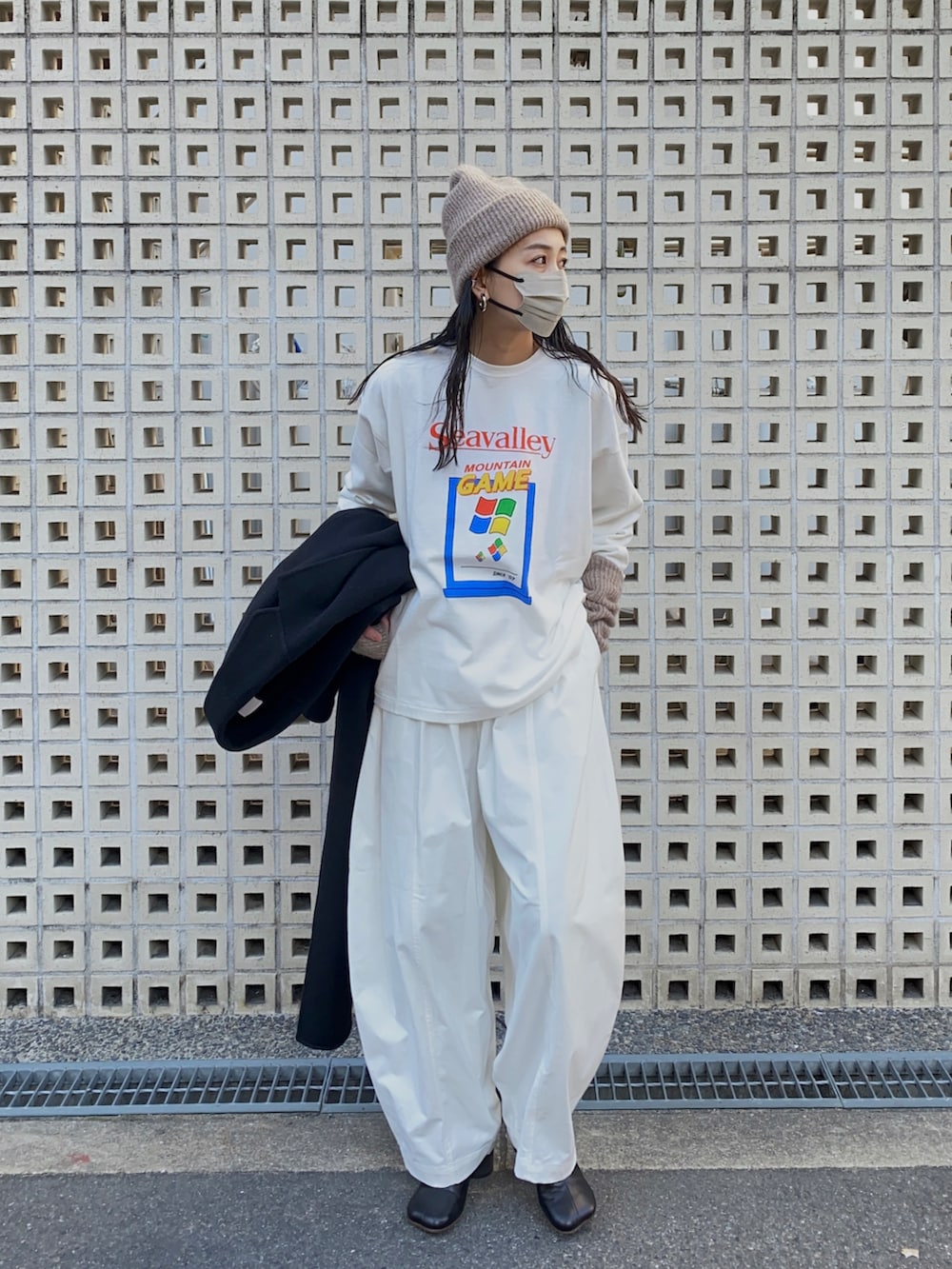 ホワイト系のTシャツ/カットソー、ホワイト系のチノパンツ、ブラック系のブーツを着用したレディースの冬コーディネートの2枚目の写真