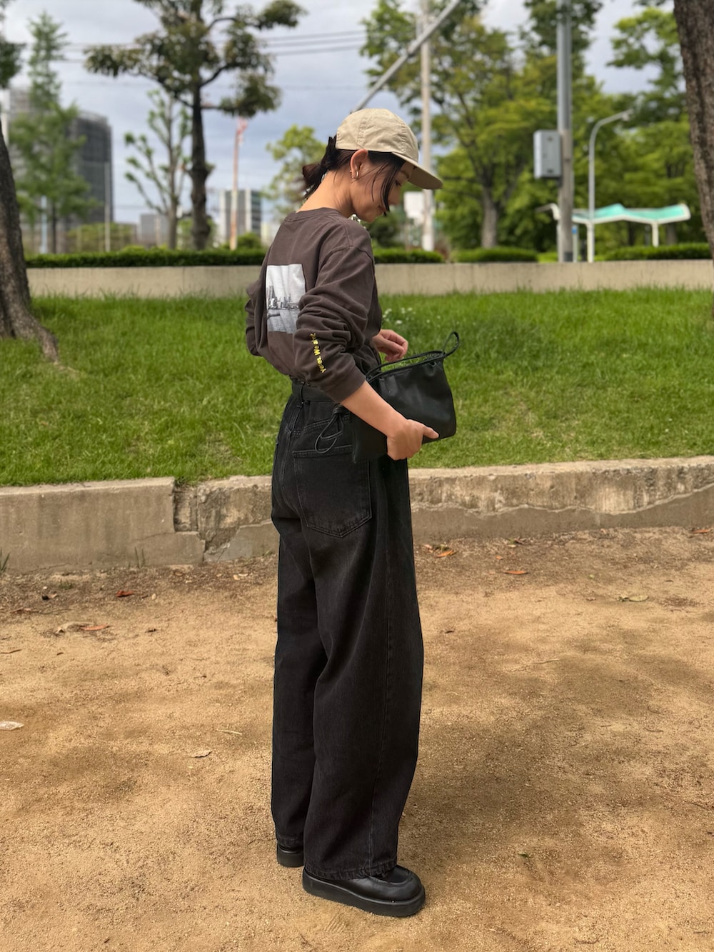 ブラック系のデニムパンツ、グレー系のTシャツ/カットソー、ブラック系のローファーを着用したレディースの春コーディネートの2枚目の写真