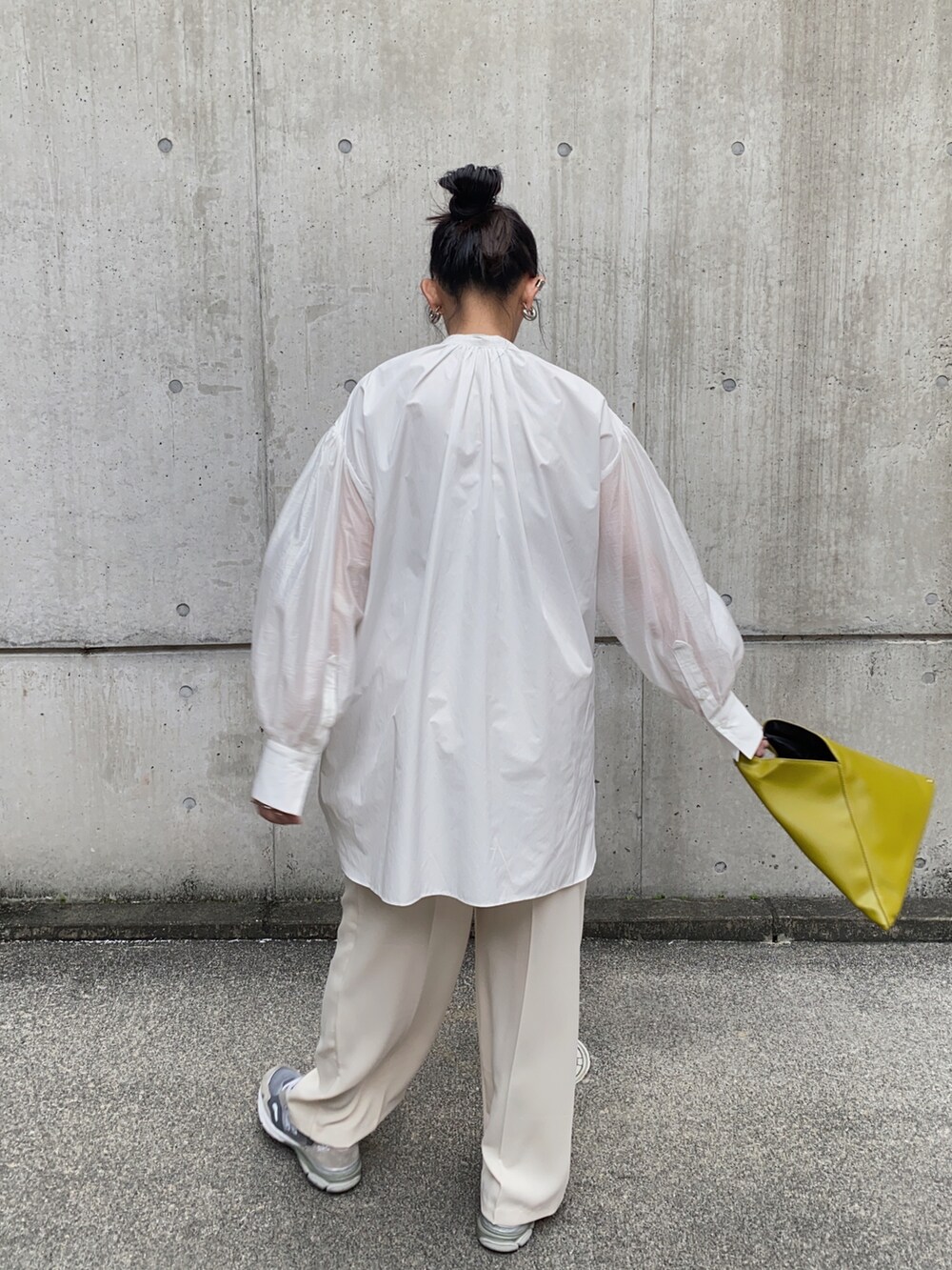 ブラック系のシャツ/ブラウス、イエロー系のハンドバッグ、グレー系のスニーカーを着用したレディースの秋コーディネートの2枚目の写真