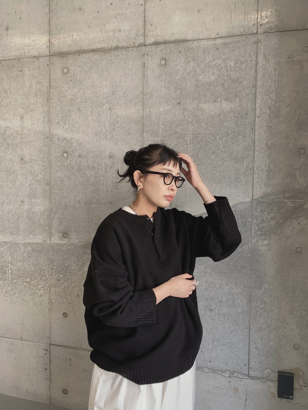 ブラック系のニット/セーター、ホワイト系のチノパンツ、ブラック系のブーツを着用したレディースの秋コーディネートの2枚目の写真