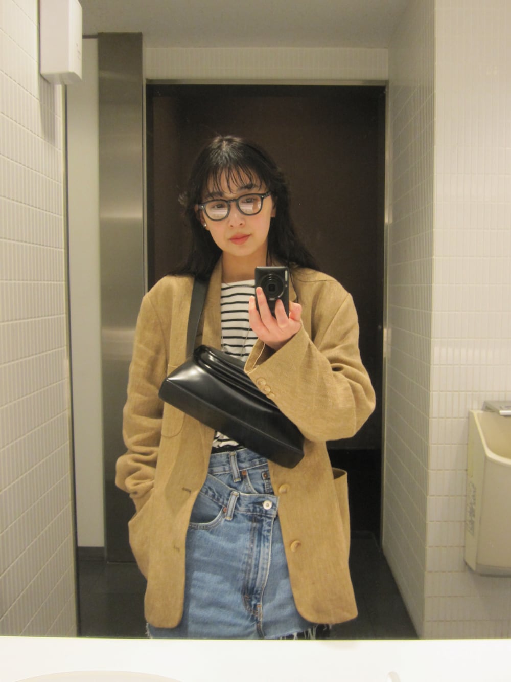 ブラック系のTシャツ/カットソー、ブラック系のスラックス、ブラック系のブーツを着用したレディースの春コーディネートの4枚目の写真