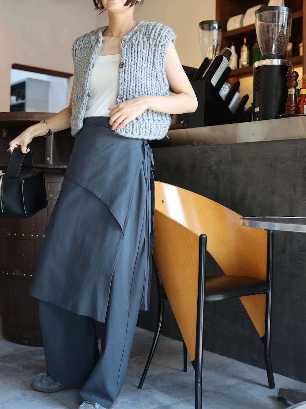 グレー系のスラックス、グレー系のスニーカー、ホワイト系のチューブトップを着用したレディースの秋コーディネートの4枚目の写真