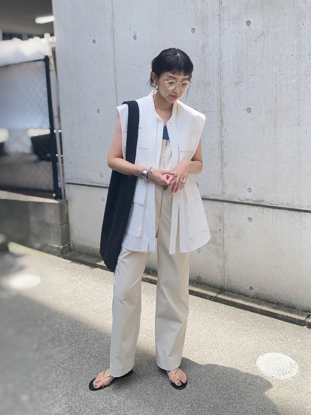 ホワイト系のサロペット/オーバーオール、ブラック系のトートバッグ、ゴールド系のサンダルを着用したレディースの夏コーディネートの3枚目の写真