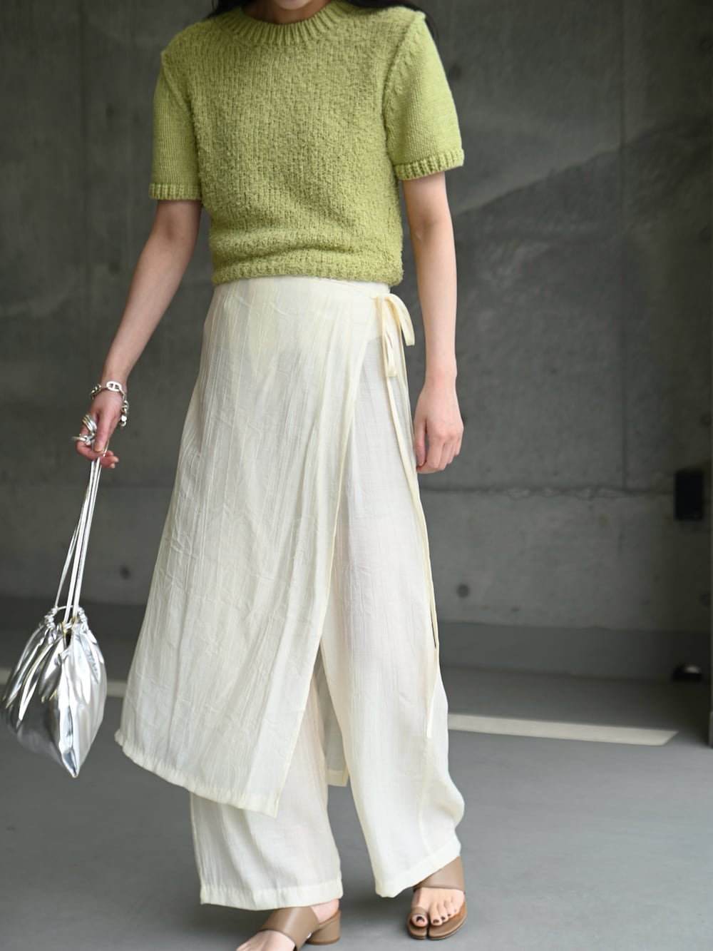 グリーン系のニット/セーター、ホワイト系のその他パンツ、ブラウン系のサンダルを着用したレディースの夏コーディネートの3枚目の写真
