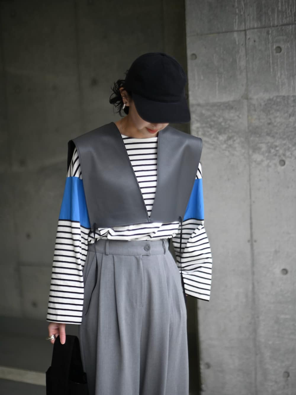 ブルー系のTシャツ/カットソー、グレー系のベスト、グレー系のスラックスを着用したレディースの春コーディネートの3枚目の写真