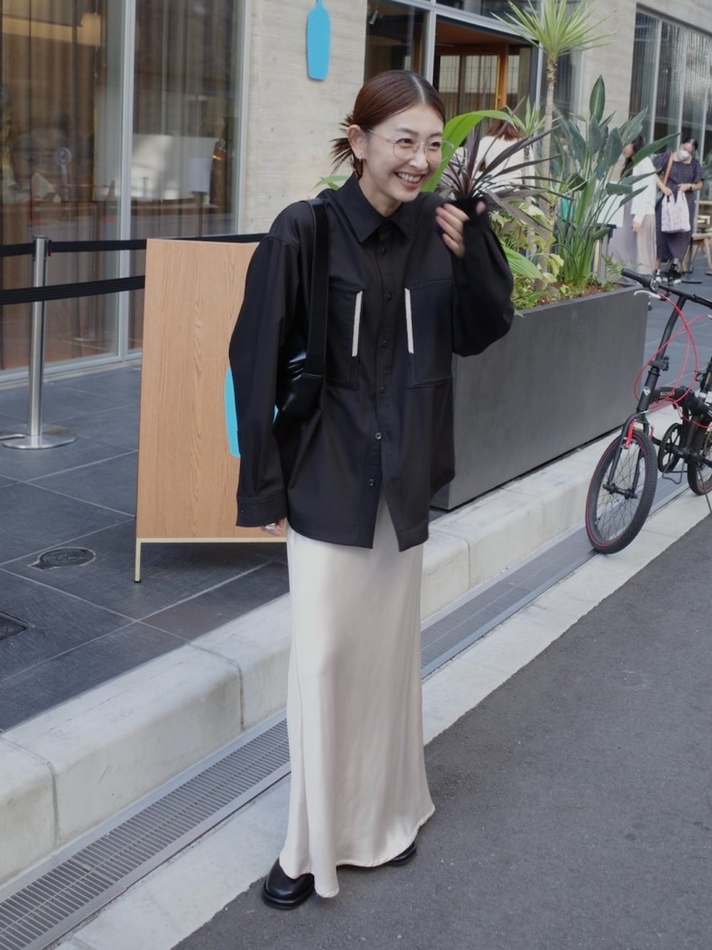 ブラック系のシャツ/ブラウス、ブラック系のスリッポン、ブラック系のショルダーバッグを着用したレディースの秋コーディネートの3枚目の写真