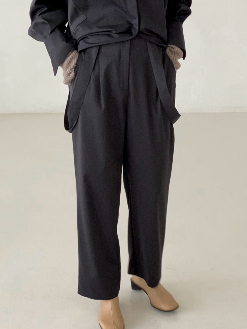 グレー系のシャツ/ブラウス、グレー系のスラックス、ベージュ系のニットキャップ/ビーニーを着用したレディースの秋コーディネートの4枚目の写真