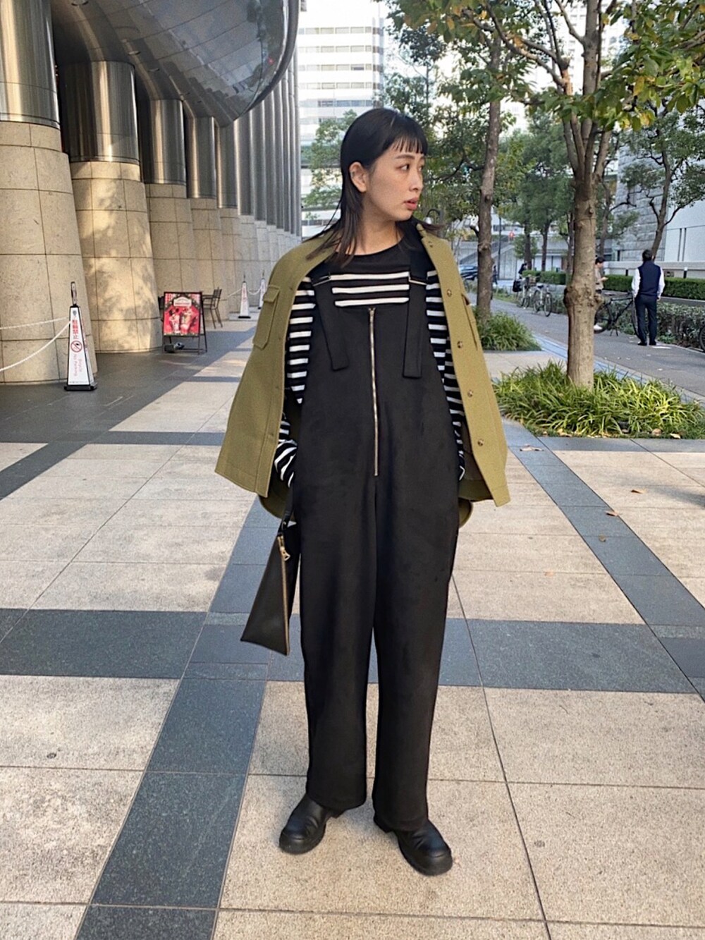 ブラック系のサロペット/オーバーオール、ブラック系のTシャツ/カットソー、グリーン系のその他アウターを着用したレディースの秋コーディネートの2枚目の写真