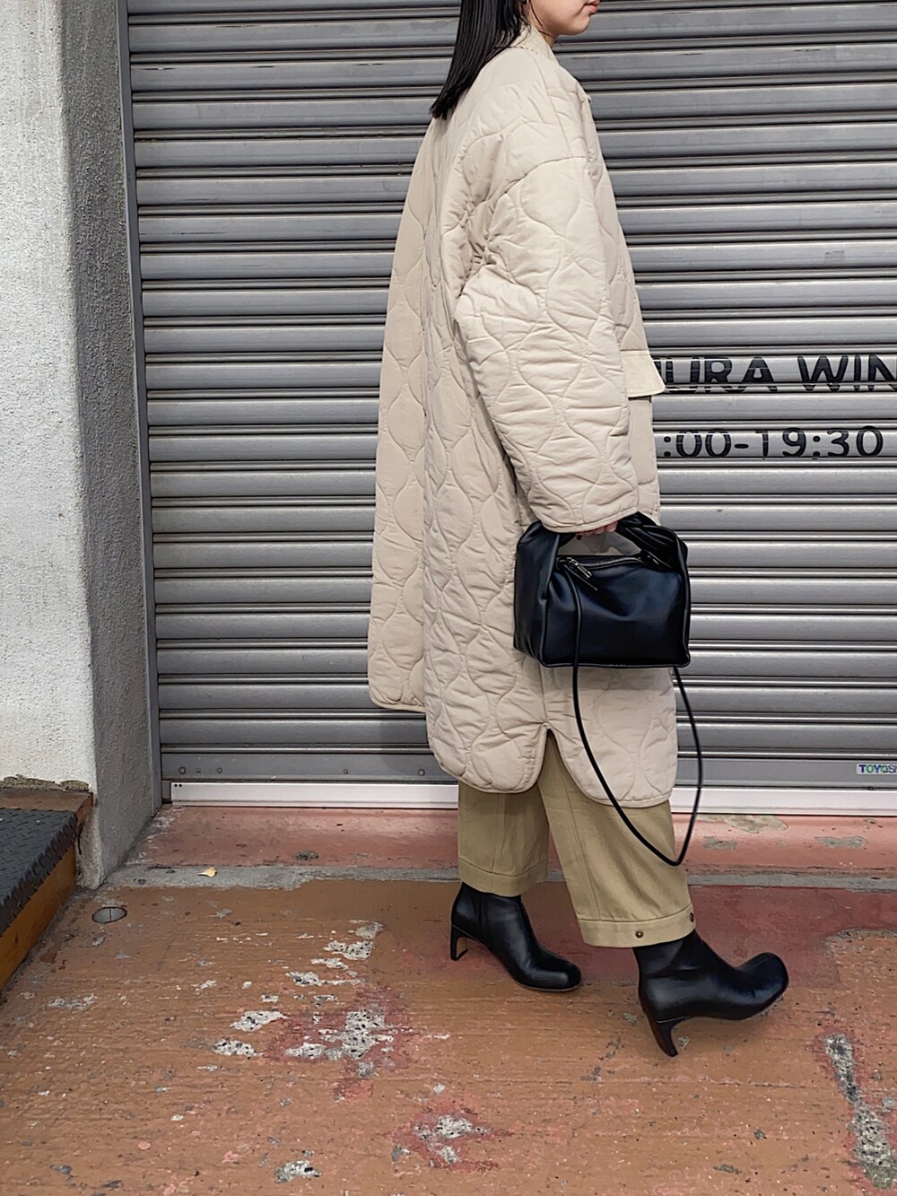ベージュ系のダウンジャケット/コート、ブラック系のブーツを着用したレディースの冬コーディネートの4枚目の写真