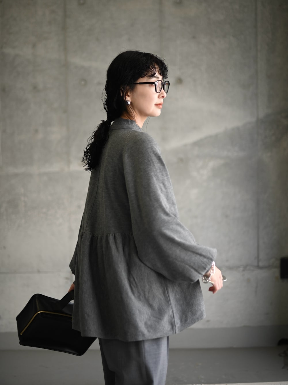 グレー系のニット/セーター、グレー系のスラックス、グレー系のスニーカーを着用したレディースの冬コーディネートの4枚目の写真