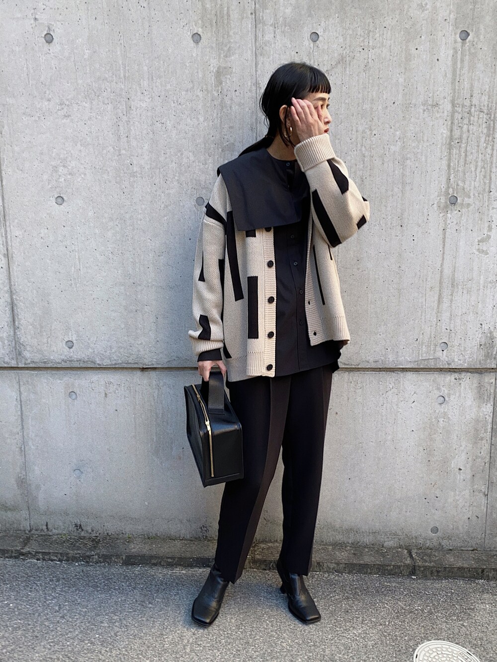 ベージュ系のカーディガン/ボレロ、ブラック系のシャツ/ブラウス、ブラック系のブーツを着用したレディースの冬コーディネートの2枚目の写真