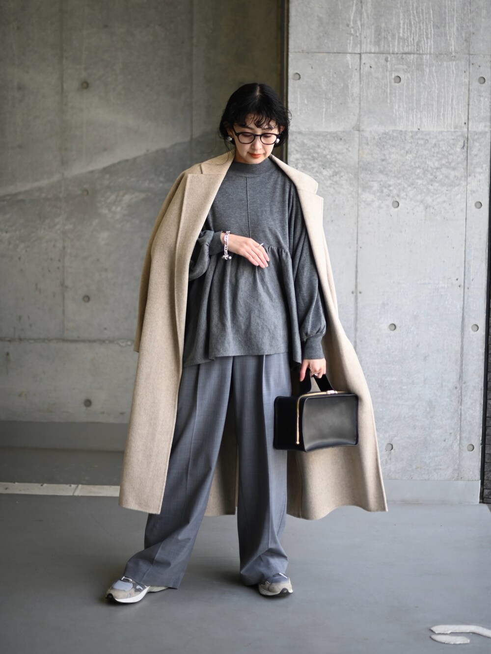 グレー系のニット/セーター、グレー系のスラックス、グレー系のスニーカーを着用したレディースの冬コーディネートの5枚目の写真