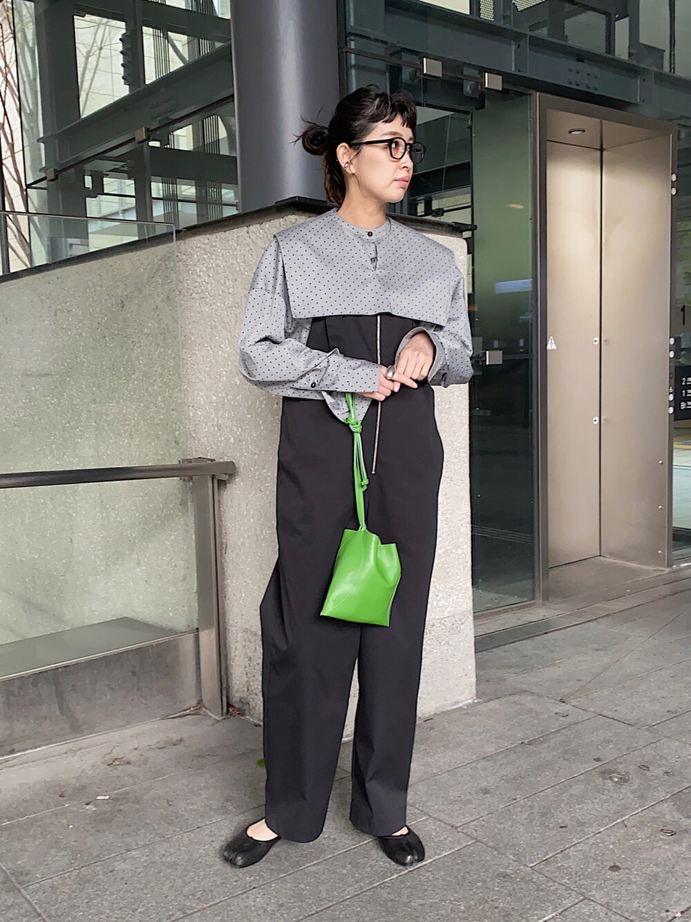 ブラック系のシャツ/ブラウス、ブラック系のサロペット/オーバーオール、グリーン系のハンドバッグを着用したレディースの春コーディネートの2枚目の写真