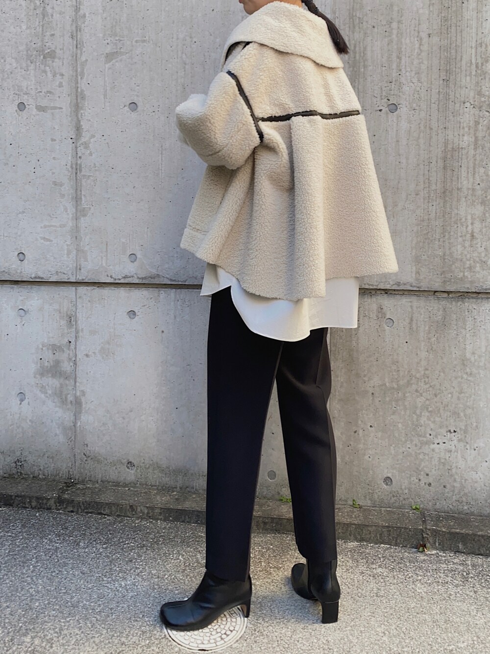 ブラック系のその他アウター、ホワイト系のシャツ/ブラウス、ゴールド系のイヤリングを着用したレディースの冬コーディネートの3枚目の写真