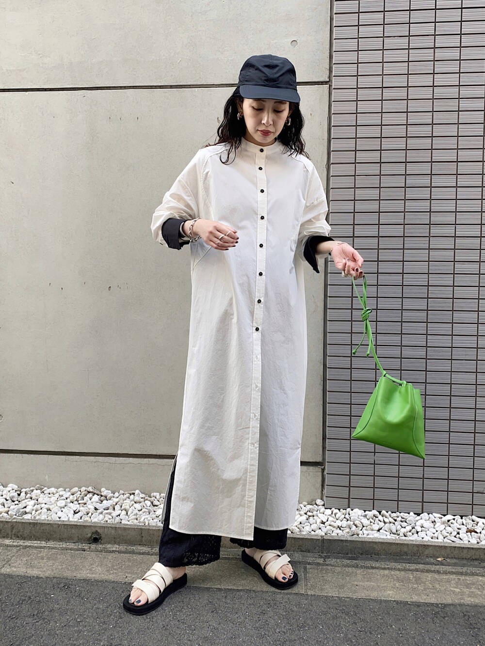 グリーン系のハンドバッグ、ブラック系のその他パンツ、ブラック系のシャツワンピースを着用したレディースの春コーディネートの4枚目の写真