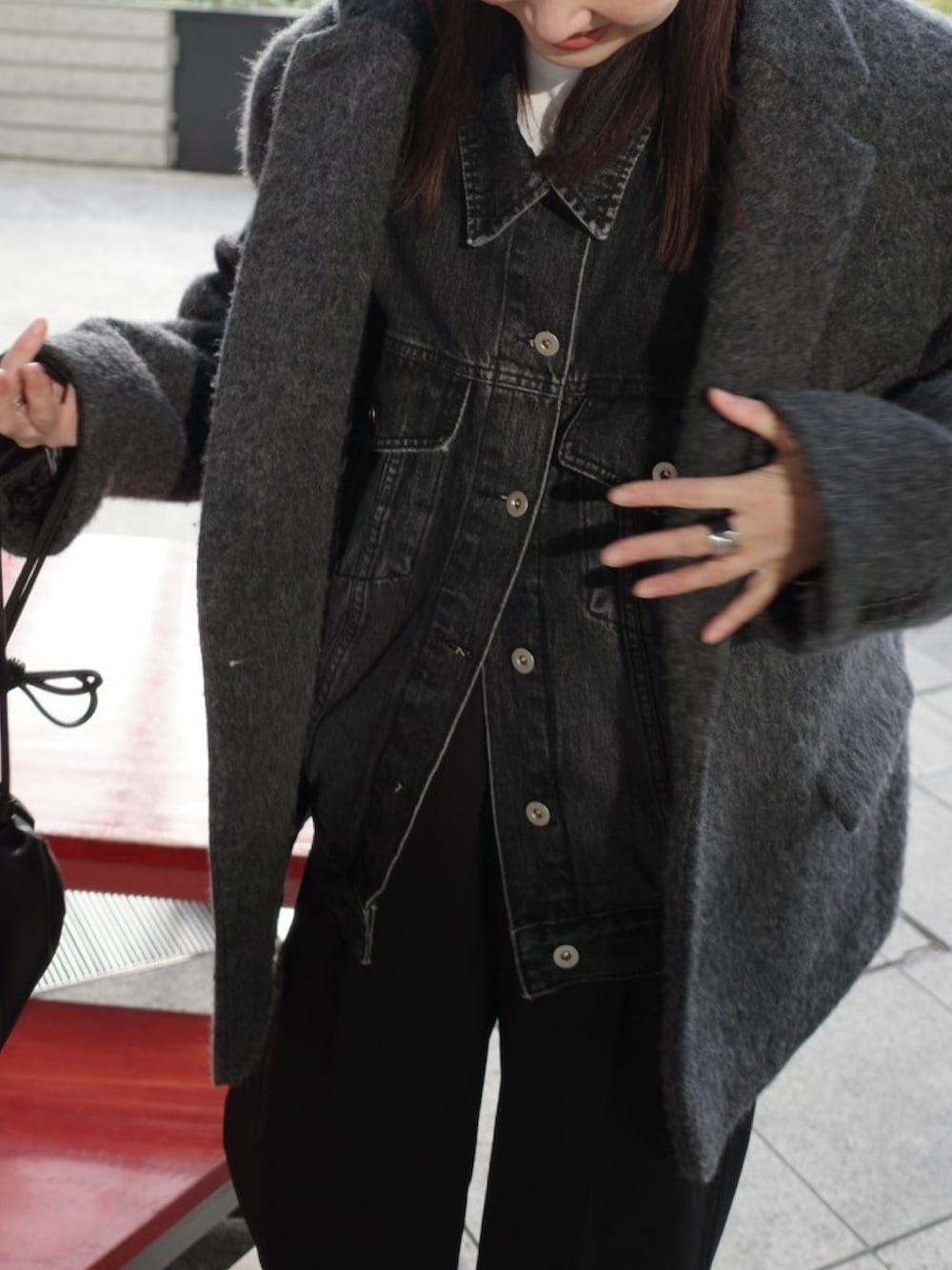 ブラック系のデニムジャケット、ブラック系のスラックス、ブラック系のローファーを着用したレディースの冬コーディネートの3枚目の写真