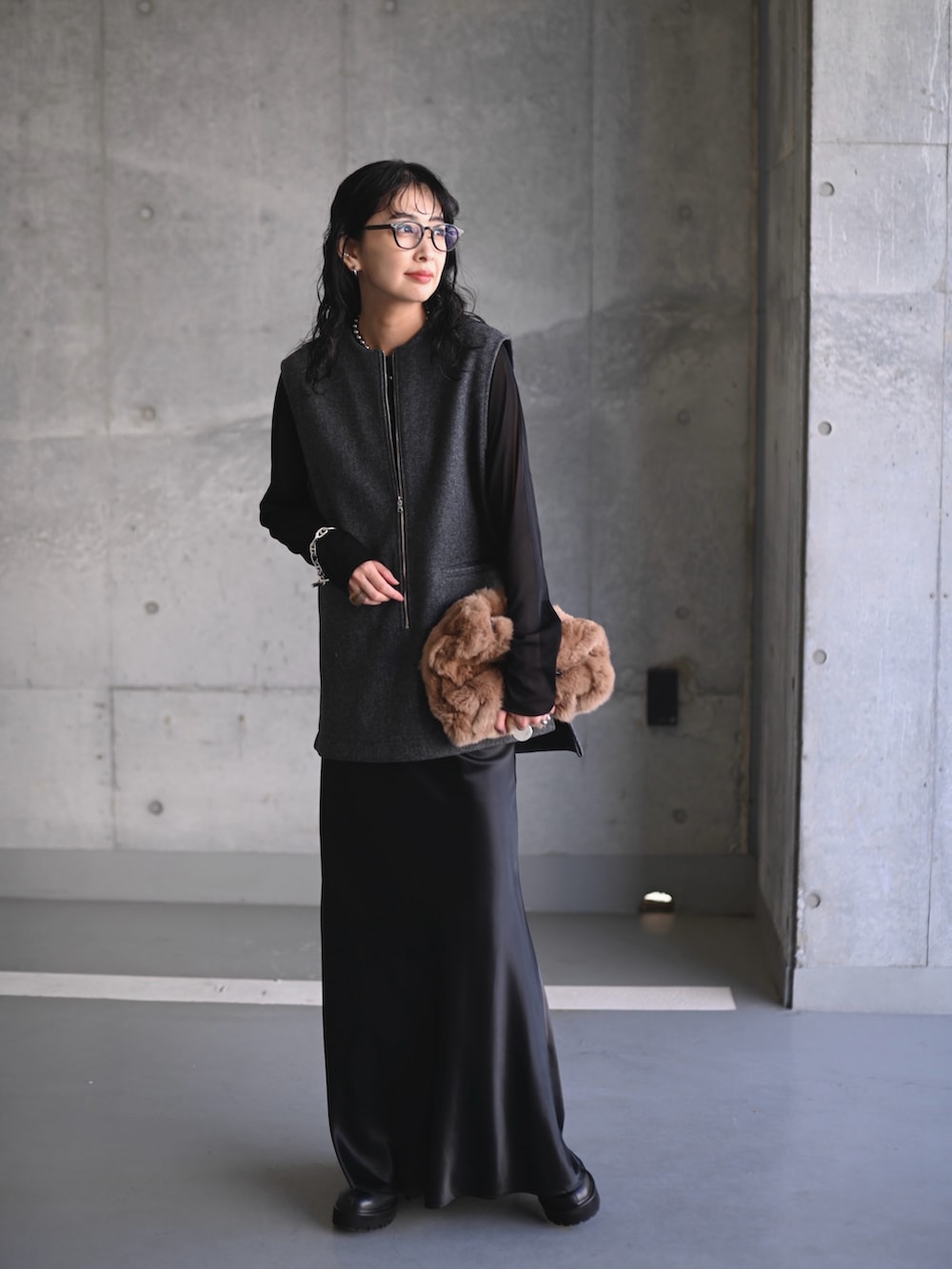 グレー系のベスト、ブラック系のTシャツ/カットソー、ブラック系のスカートを着用したレディースの秋コーディネートの5枚目の写真