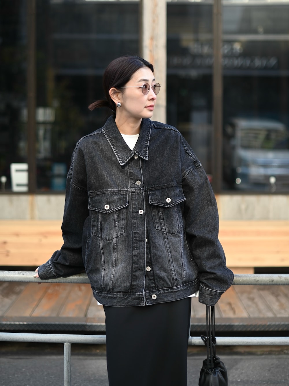 ブラック系のデニムジャケット、ブラック系のスカート、ブラック系のローファーを着用したレディースの春コーディネートの3枚目の写真