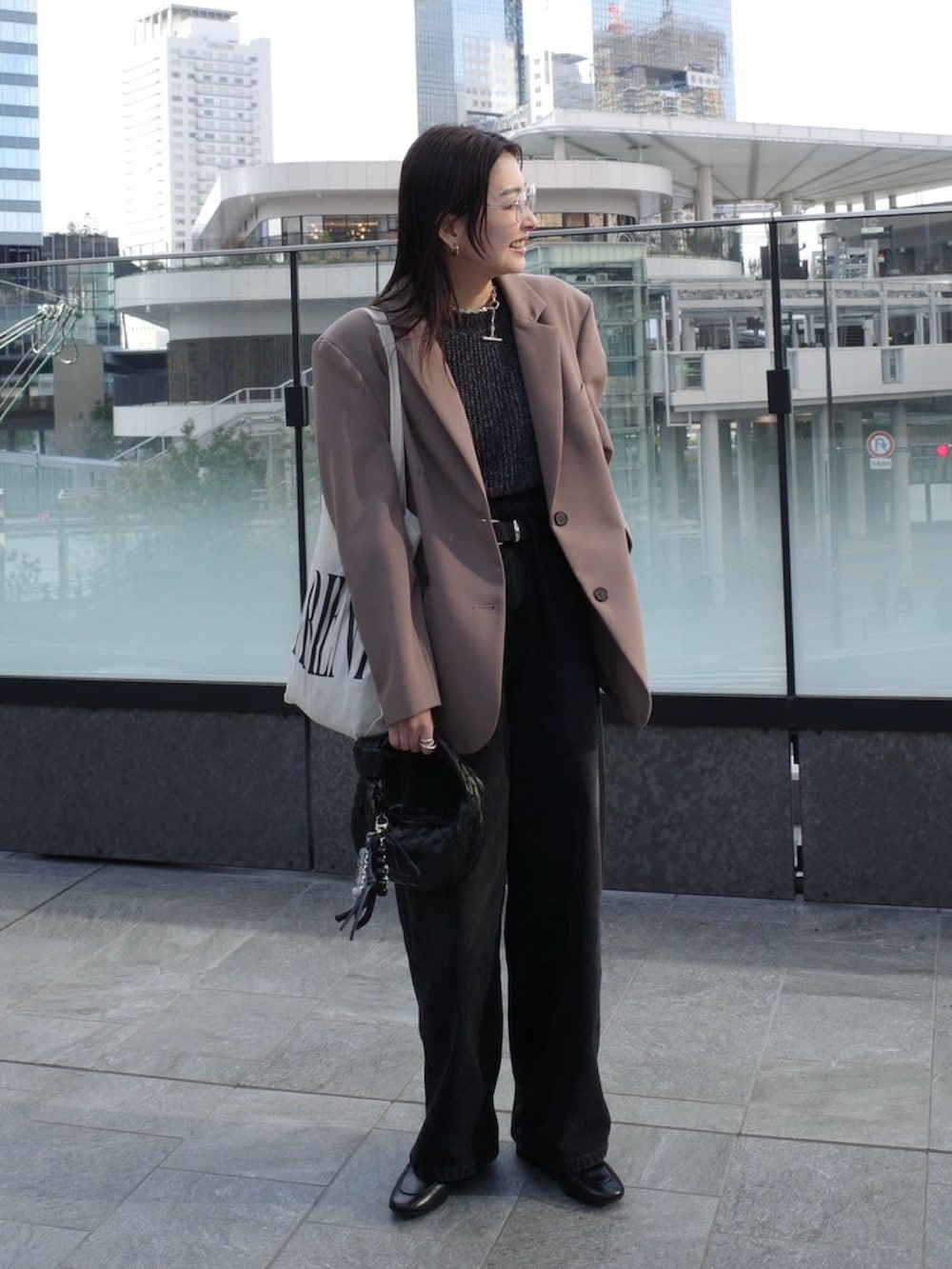 ブラック系のローファー、ブラック系のニット/セーター、ブラック系のデニムパンツを着用したレディースの春コーディネートの5枚目の写真